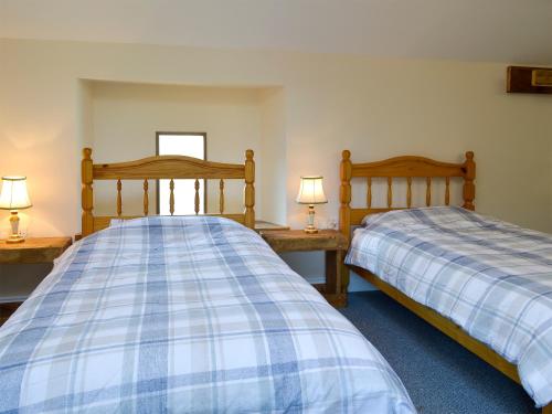 dos camas sentadas una al lado de la otra en un dormitorio en Snipelands Barn, en Wedmore