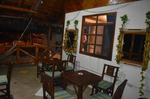 a dining room with tables and chairs and windows at Hotel SoleMare in Montañita