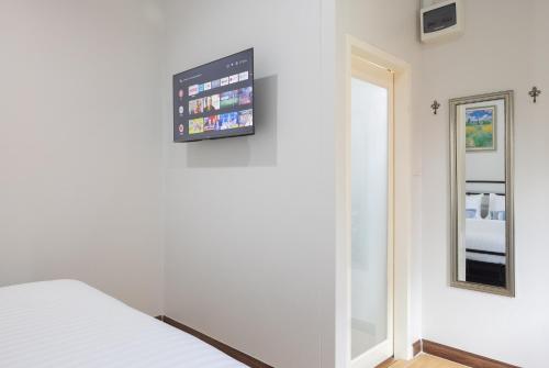 a room with a bed and a television on the wall at Picha Ville Resort in Watthana Nakhon