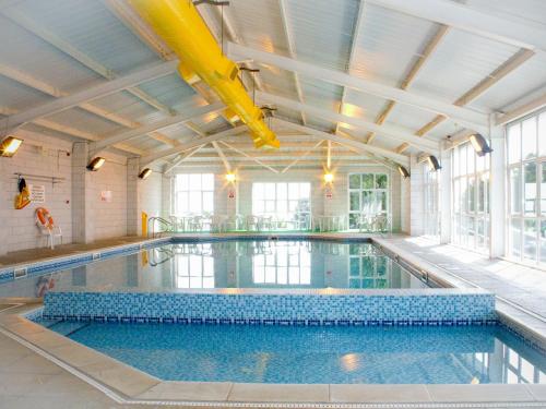 an indoor swimming pool with a large ceiling at The Mealhouse-UK12902 in Pelynt