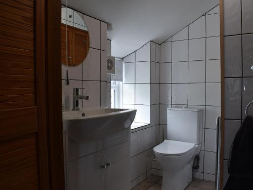 a white bathroom with a sink and a toilet at Tinners Gate in Saint Cleer