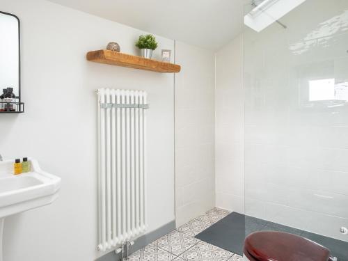 a bathroom with a glass shower and a white radiator at High Ranachan in Campbeltown