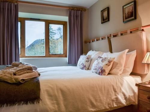 a bedroom with a large bed with a window at Over Brandelhow in Borrowdale