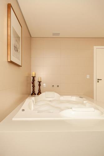 a large white bath tub in a room at Villa Toscana - Vale dos Vinhedos in Bento Gonçalves