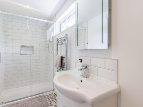 a white bathroom with a sink and a shower at Kingsleys Lodge in Barnstaple