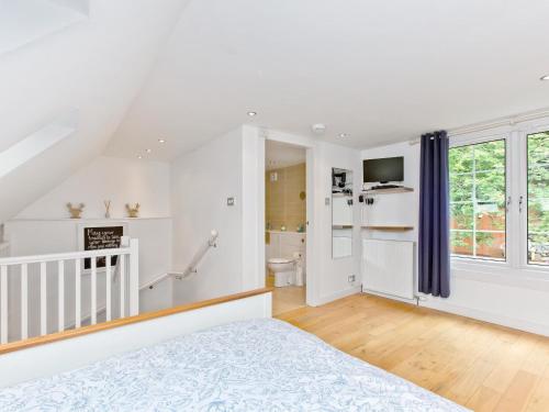 a white bedroom with a bed and a staircase at Dowies Mill Lane in Edinburgh