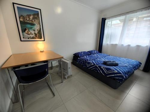 1 dormitorio con cama, escritorio y sofá cama en PROMO! Near Train Station, FREE WIFI! en Melbourne