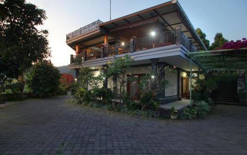 a building with a balcony with plants on it at Rostika Hotel Sekumpul in Buleleng