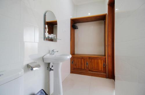 een badkamer met een wastafel en een houten deur bij Rostika Hotel & Camping Sekumpul in Buleleng