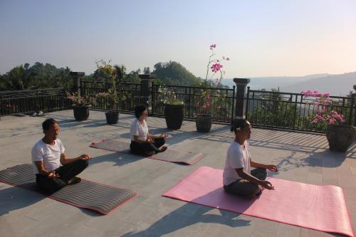 a group of people sitting in a yoga pose at Rostika Hotel Sekumpul in Buleleng