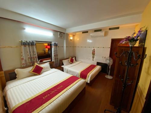Habitación de hotel con 2 camas y espejo en Sapa Local House, en Sa Pa