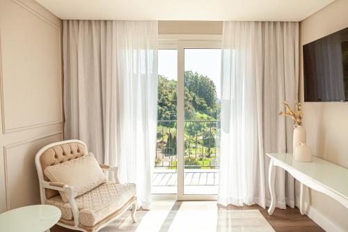 a white chair in a room with a window at Villa Toscana - Vale dos Vinhedos in Bento Gonçalves