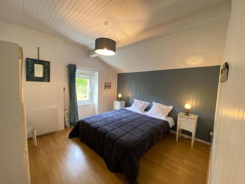 1 dormitorio con 1 cama con manta azul en Charming, quiet holiday home on the west coast of the Cotentin en Bréhal