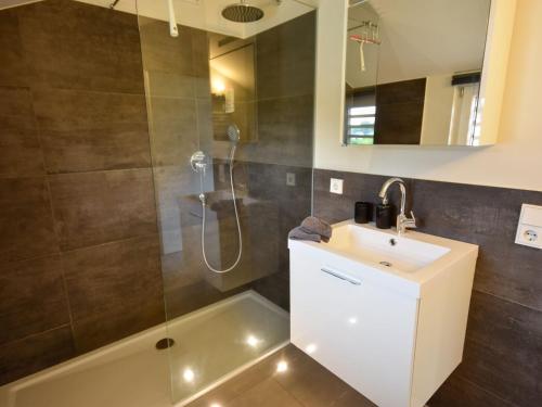 een badkamer met een wastafel en een douche bij Detached holiday home in the Vulkaneifel in Berlingen