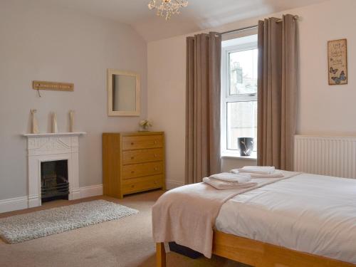 a bedroom with a bed and a fireplace and a window at Rowan House in Threlkeld