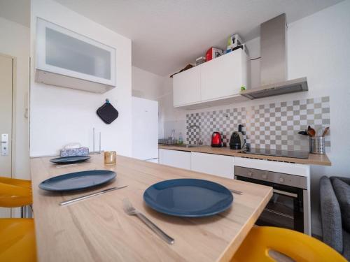 une cuisine avec une table en bois avec des assiettes bleues dessus dans l'établissement Appartement tout équipé climatisé Terrasse Hôpital de la Timone, à Marseille