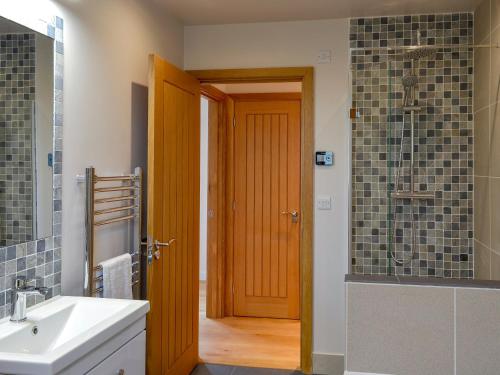 ein Badezimmer mit einer Holztür und einem Waschbecken in der Unterkunft The Horse Gin - Uk11024 in East Worlington