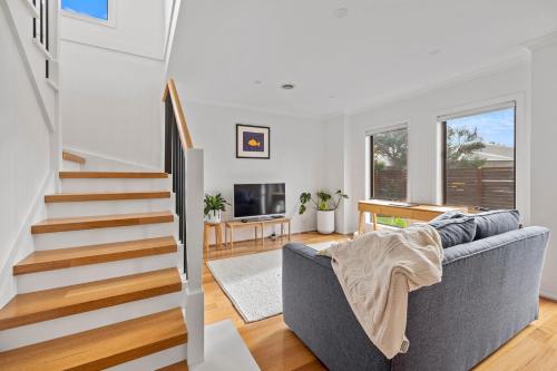 a living room with a couch and a tv at Paperbark Escape in Inverloch