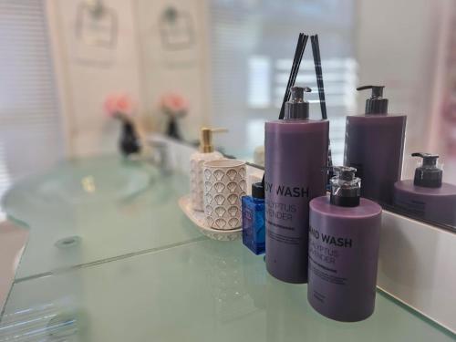 three bottles ofodorizers sitting on a counter in a bathroom at 11 chartwell in Brisbane