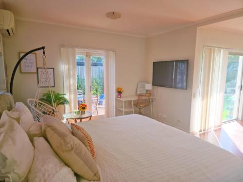 a bedroom with a large bed with a tv on the wall at 11 chartwell in Brisbane
