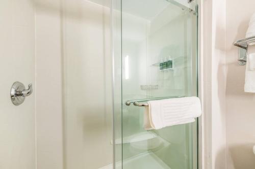 a shower with a glass door and a towel at Fairfield by Marriott Inn & Suites Greensboro Coliseum Area in Greensboro