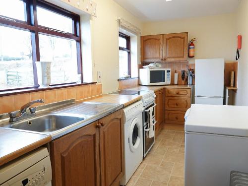 a kitchen with a sink and a dishwasher at Seaforth Cottage in Cononbridge