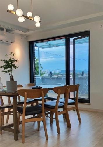 a dining room with a table and chairs and a large window at The Stair House in Suwon