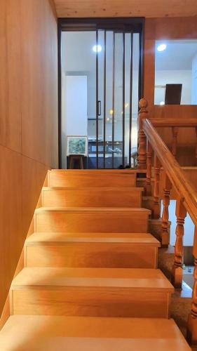 een trap met houten trappen en een glazen deur bij The Stair House in Suwon