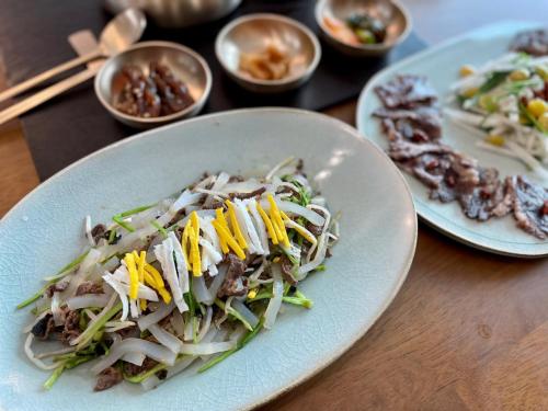 a plate of food on a table with other plates of food at The Stair House in Suwon