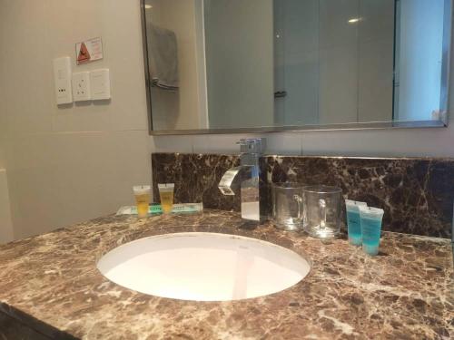 a bathroom counter with a sink and a mirror at Residence-South China Sea Place by WinJ Management in Kota Kinabalu