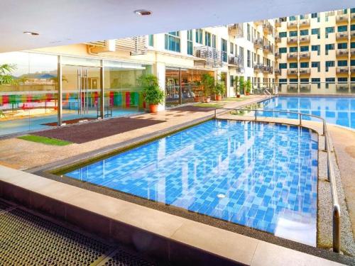 a large swimming pool in the middle of a building at Residence-South China Sea Place by WinJ Management in Kota Kinabalu