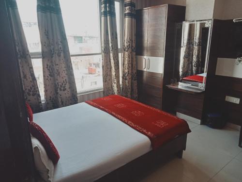 a bedroom with a bed and a window with curtains at Hotel Robin Inn in Amritsar