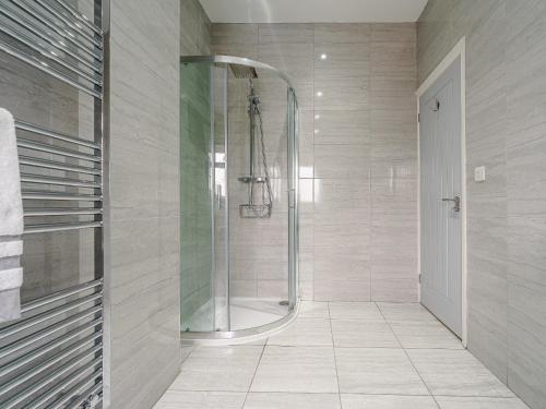 a shower with a glass door in a bathroom at Wynbec Cottage in Esh