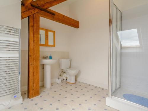 a bathroom with a toilet and a glass shower at Mulberry Cottage in North Wootton