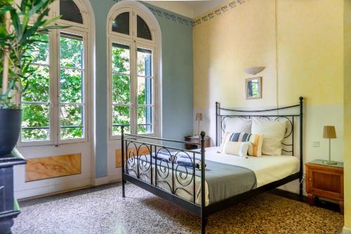 a bedroom with a bed in a room with windows at 5 Family Apartments with Pool & Large Garden in Historic Pézenas Convent in Pézenas