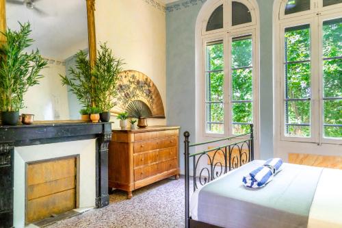 a bedroom with a bed and a fireplace at 5 Family Apartments with Pool & Large Garden in Historic Pézenas Convent in Pézenas