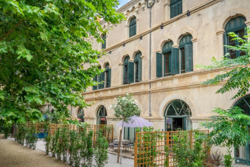 a building with an umbrella in front of it at 5 Family Apartments with Pool & Large Garden in Historic Pézenas Convent in Pézenas