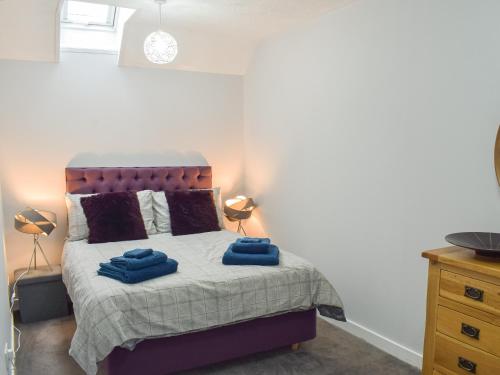 1 dormitorio con 1 cama con 2 toallas azules en The Cottage en Girvan