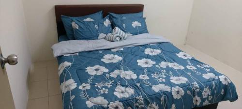 a bed with a blue and white comforter and pillows at Bambob Homestay and Car Rental in Gambang