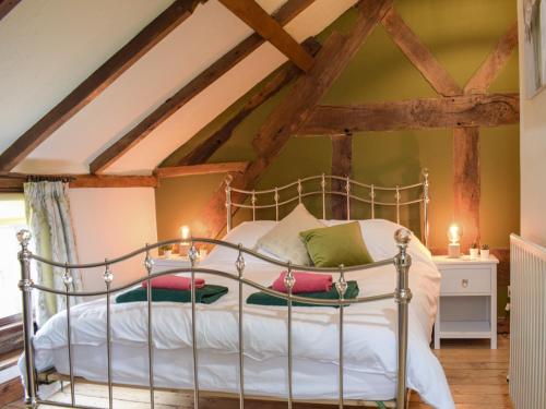 a bedroom with a metal bed in a attic at Ysgubor Hir in Trefeglwys