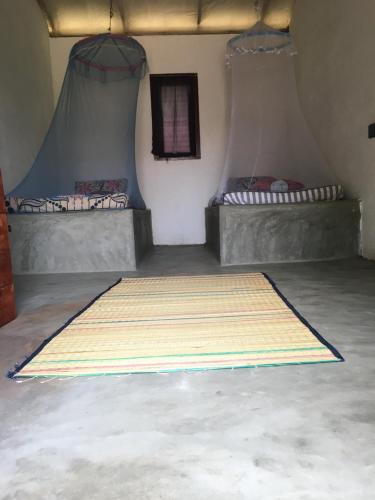 a room with two beds and a large rug on the floor at MKS - Kite & Wing Foil camp in Kalpitiya