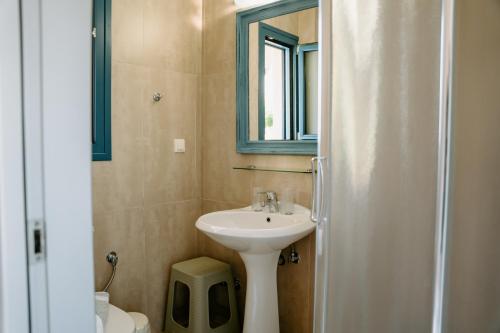 a bathroom with a sink and a mirror at Karavostasi Beach Hotel in Perdika