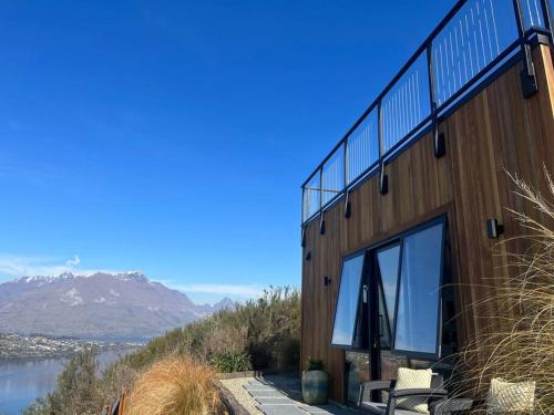 a building with a view of the water and mountains at Views on Florence in Queenstown