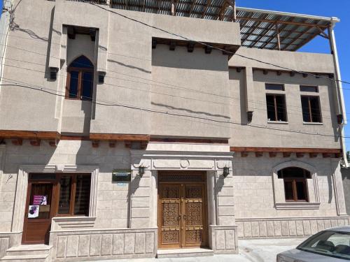 un edificio con puertas de madera en un lateral en Central Asia Hotel, en Bukhara