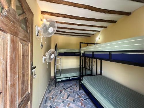 a room with two bunk beds and a door at Terrapin village and hostel in Pwani Mchangani
