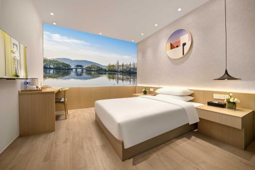 杭州市にあるQuantum Inn - Hangzhou East Railway Stationのベッドルーム(大型ベッド1台、大きな窓付)