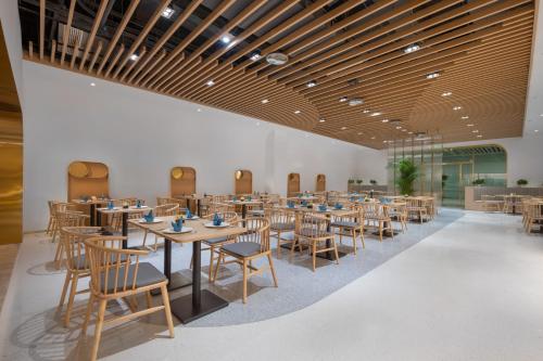 a dining room with wooden tables and chairs at Quantum Inn - Hangzhou East Railway Station in Hangzhou