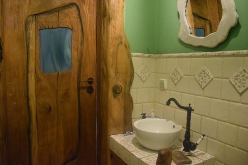 a bathroom with a sink and a wooden door at Chatka skrzatka in Kruki