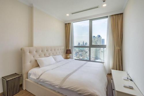 a bedroom with a large bed and a large window at DongDong Luxury Apartment in Vinhomes Central Park in Ho Chi Minh City