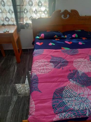 a bedroom with a bed with a pink blanket at CITY APARTMENTS in Guruvāyūr